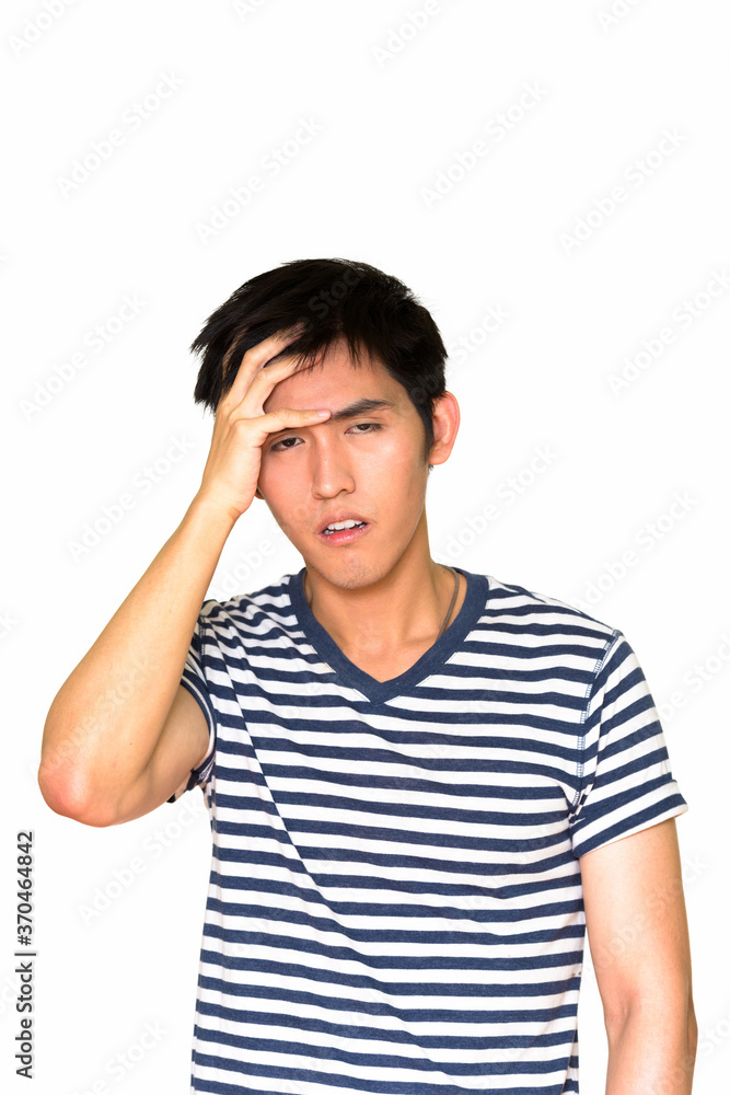 Studio shot of tired Asian man isolated against white background Studio shot of tired Asian man isolated against white background