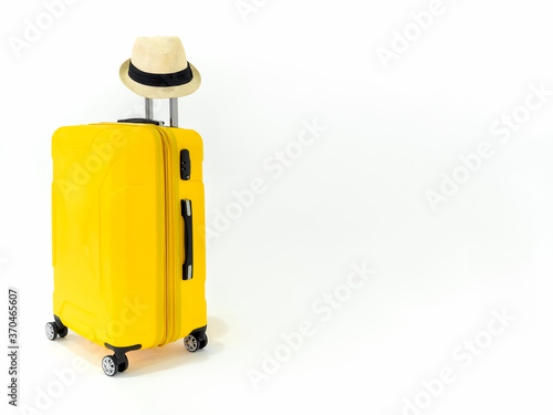 Yellow suitcase with straw hat isolated on white background.
