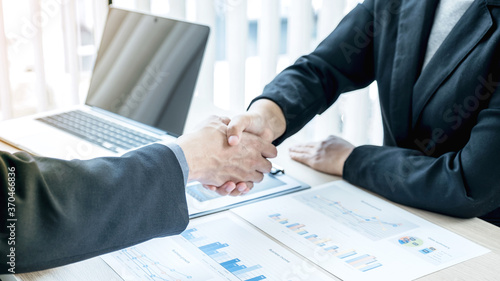 businessmen and businesswomen shacking hands after meeting to plan strategies to increase business income. Have a brainstorming graph analysis and discussing for the new target success