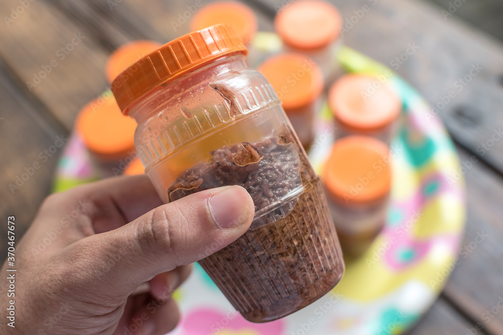 Holding Bagoong in plastic containers for sale. Small business