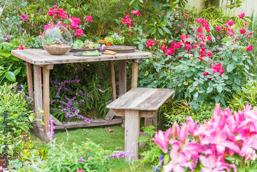 Gardening tools on table and spring flower on the terrace in garden Gardening tools on table and spring flower on the terrace in garden