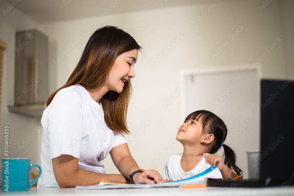 Happy mother and smiling daughter together painting using markers. Mother helping adopted child with art homework. Cheerful mother and asian little girl making painting at home. Happy mother and smiling daughter together painting using markers. Mother helping adopted child with art homework. Cheerful mother and asian little girl making painting at home.