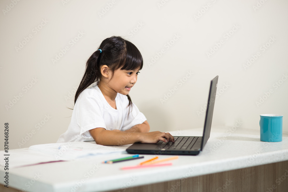 Coronavirus Outbreak. Lockdown and school closures. Schoolgirl watching online education class, happy talking with teacher on the internet at home. COVID-19 pandemic forces children online learning Coronavirus Outbreak. Lockdown and school closures. Schoolgirl watching online education class, happy talking with teacher on the internet at home. COVID-19 pandemic forces children online learning