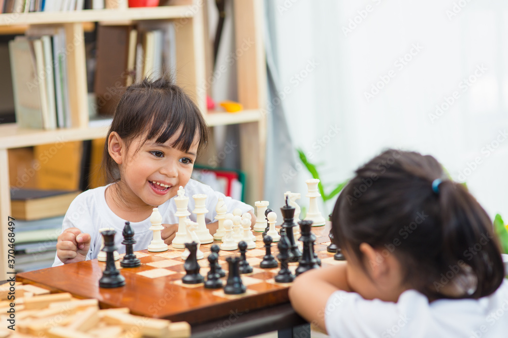 Kids playing chess - one of them just captured a pawn and celebrates Kids playing chess - one of them just captured a pawn and celebrates
