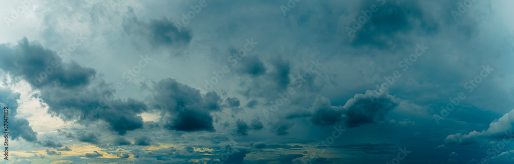 Panorama evening sky with blue, white and yellow sunlight. Summer evening bad weather background. Rain is coming.