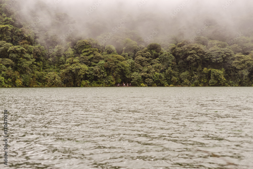 lake in the Cerro Chato volcano cone surrounded by vegetation and fog
