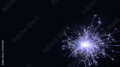 Burning colored sparkler, pyrotechnics on a black background. Merry christmas and happy new year, background, copy space