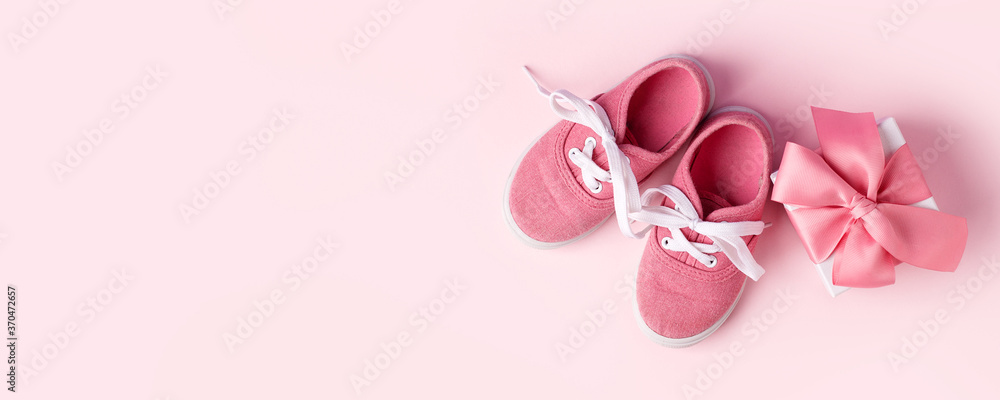 Pink baby shoes and gift present box, concept of first steps, birthday, expectation, pregnancy, maternity, motherhood, parenthood. Monochrome card for baby shower party, copy space, banner, invitation