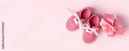 Pink baby shoes and gift present box, concept of first steps, birthday, expectation, pregnancy, maternity, motherhood, parenthood. Monochrome card for baby shower party, copy space, banner, invitation
