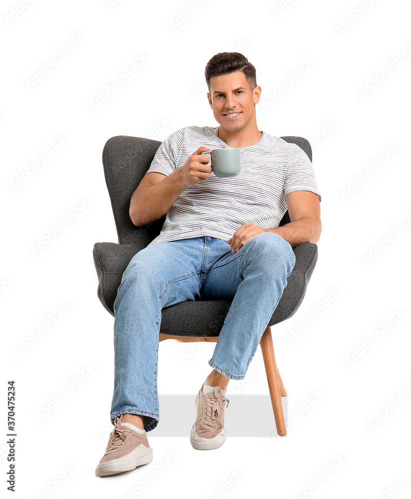 Young man with coffee relaxing in armchair on white background Young man with coffee relaxing in armchair on white background