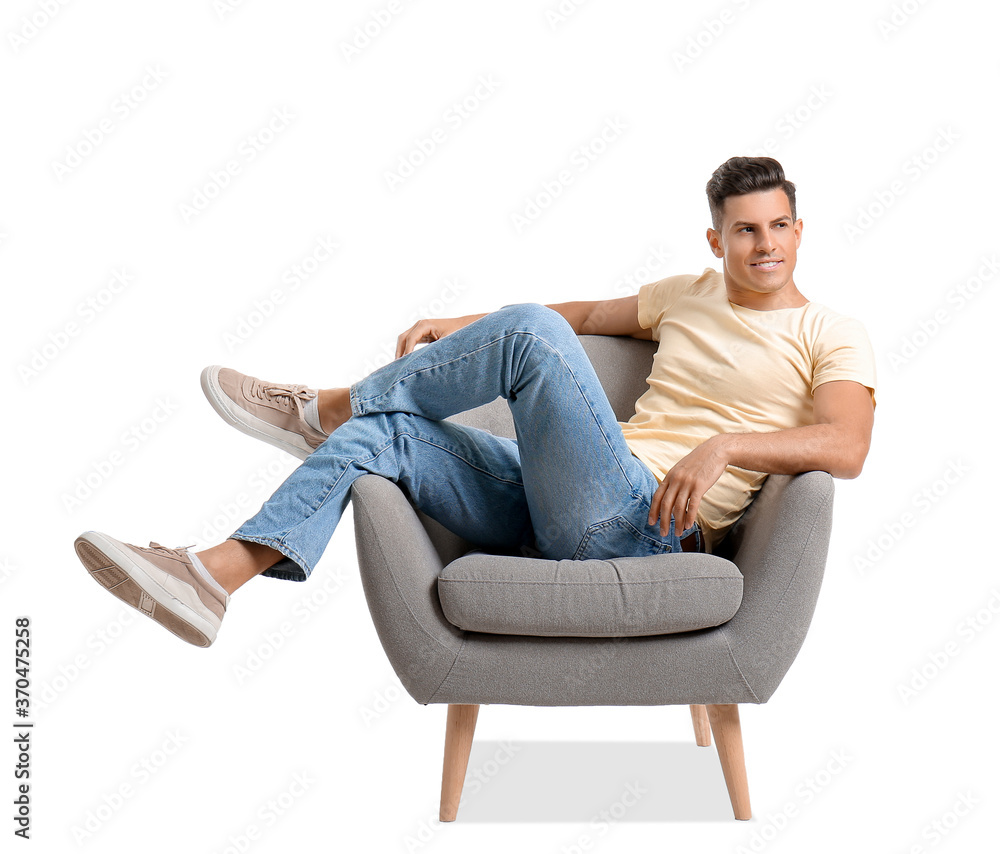 Young man relaxing in armchair on white background