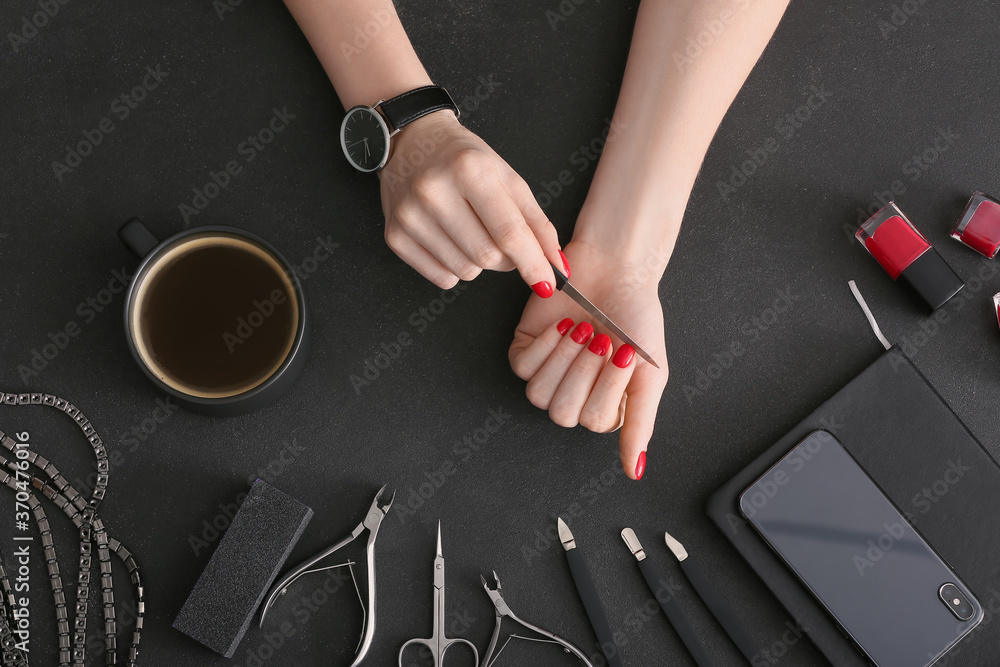 Woman doing manicure on dark background - obrazy, fototapety, plakaty 
