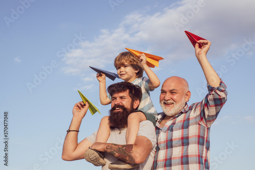 Grandfather, father and son are hugging and having fun together.