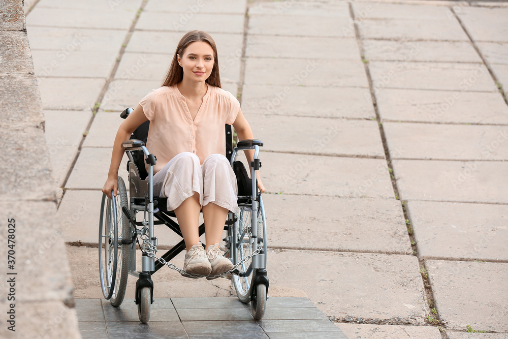 Young woman in wheelchair on ramp outdoors Young woman in wheelchair on ramp outdoors