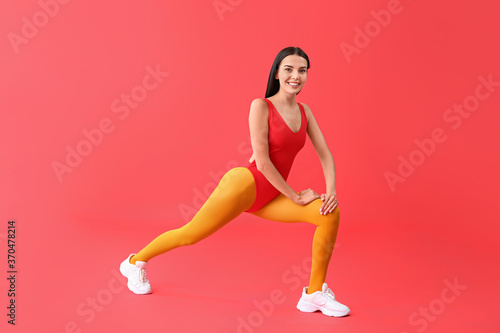 Young woman doing aerobics on color background