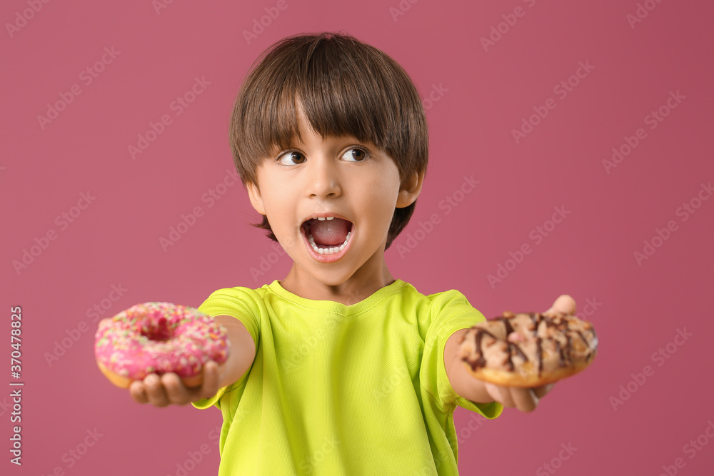 Funny little boy with donuts on color background Funny little boy with donuts on color background