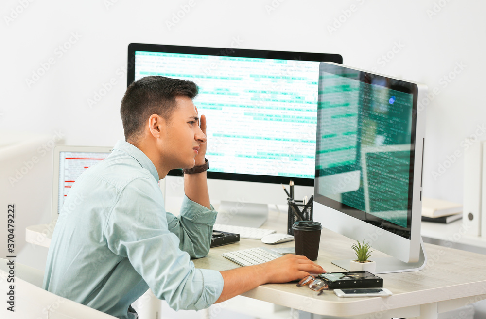Stressed male programmer working in office Stressed male programmer working in office