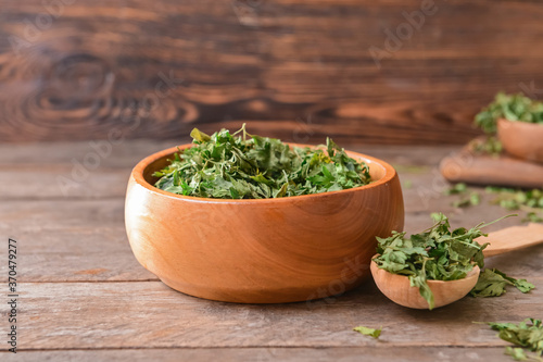 Bowl with dry parsley on table