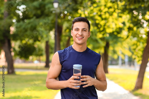 Sporty young man with bottl...