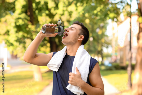 Sporty young man drinking w...