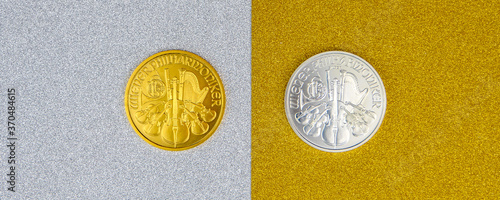 Photos silver and golden austrian mint phillharmoniker one ounce coins laying on silver and golden background