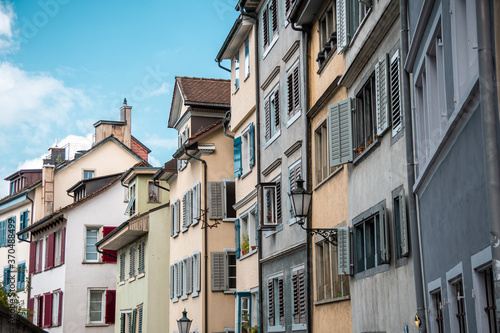 Typical painted facades of small old town houses. Facade of houses with shutters on the windows.