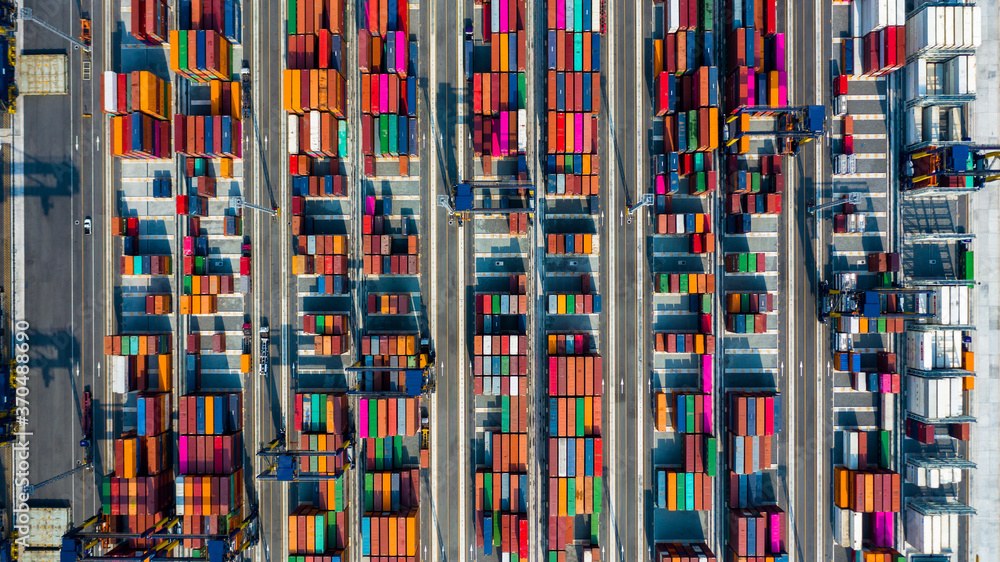 Aerial view of area with stacked containers at the port, Top view stack of freight containers in rows at the shipyard, Global business cargo logistics shipping industry export import transportation. Aerial view of area with stacked containers at the port, Top view stack of freight containers in rows at the shipyard, Global business cargo logistics shipping industry export import transportation.