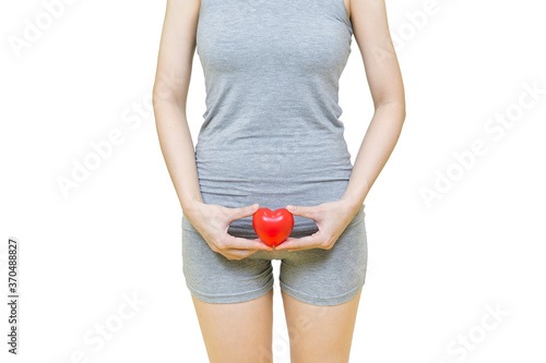 woman in gray clothes holding red heart put on the genitalia area, Itching or urinary, painful illness feeling unwell Health-care concept on white background photo