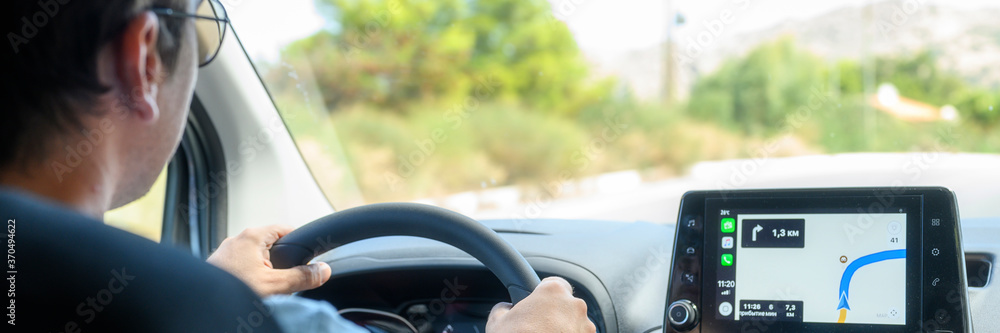 Crete / Greece - Deptember 2019: a male driver travels by car at the wheel with a Navigator. banner