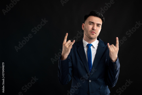 Portrait of business man wearing blue business suit and tie listen rock music