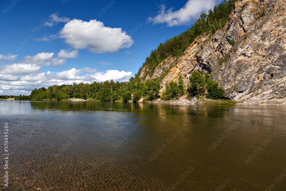 A natural landscape of river with clear water, blue sky and clouds and cliff A natural landscape of river with clear water, blue sky and clouds and cliff
