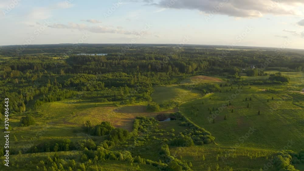 Flying over beautiful countryside landscape with field and trees, Latvian nature, summer sun. Flying over beautiful countryside landscape with field and trees, Latvian nature, summer sun.
