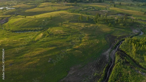 Flying over beautiful countryside landscape with field and trees, Latvian nature, summer sun.