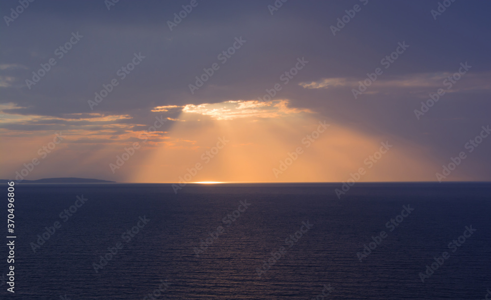 The sun shines through the cloud at sunset.Beautiful landscape