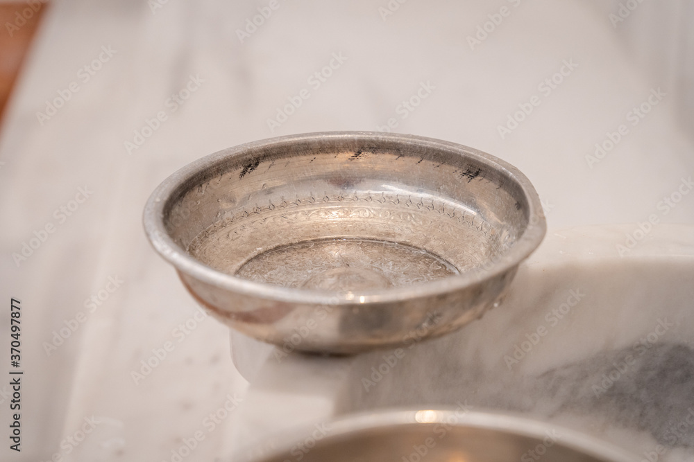 Traditional Turkish bath hammam or hamam with marble benches and sinks, taps for hot and cold water and metal bowls Traditional Turkish bath hammam or hamam with marble benches and sinks, taps for hot and cold water and metal bowls