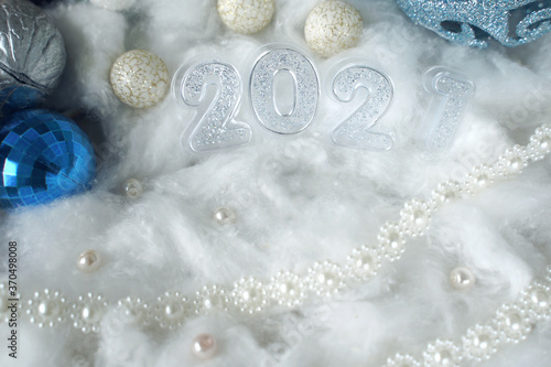blurred christmas decoration with 2021 and blue christmas balls on snow background