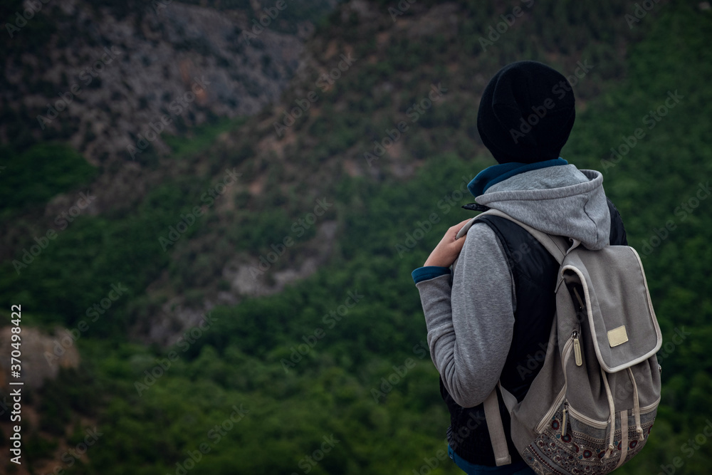 Young traveling woman on the top of the mountain cliff Young traveling woman on the top of the mountain cliff