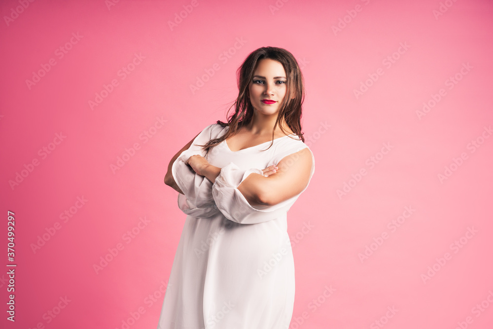 Plus size fashion model in white dress, fat woman on pink background Plus size fashion model in white dress, fat woman on pink background