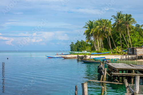 Old Pier and Boats at the Edge of a Tropical Village