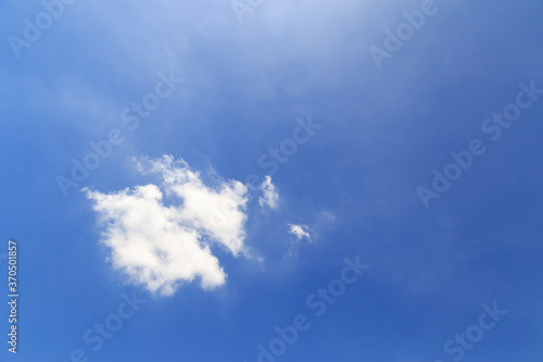 Beautiful fluffy white clouds float in the blue sky on a nice day in summer. Blue is the beautiful color of nature.