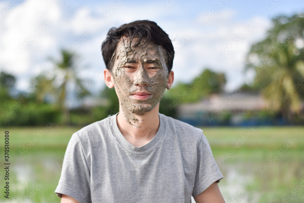 Close up of a man's face and hands covered in mud Close up of a man's face and hands covered in mud