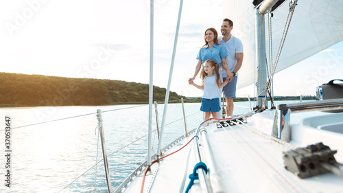 Family Embracing Standing On Yacht Relaxing On Weekend Outdoors, Panorama