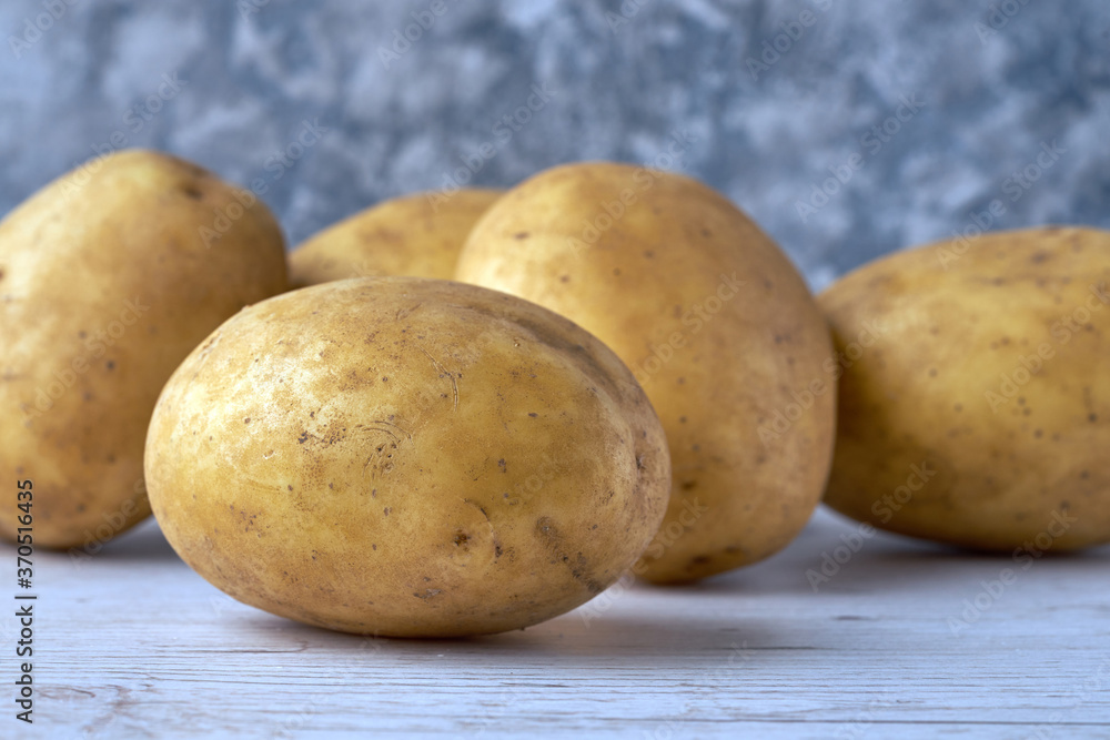 Fresh raw potatoes on textured background Fresh raw potatoes on textured background