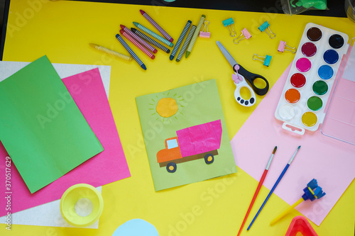 School supplies, stationery on yellow background - space for caption. Child ready to draw with pencils and make application of colored paper. Top view.