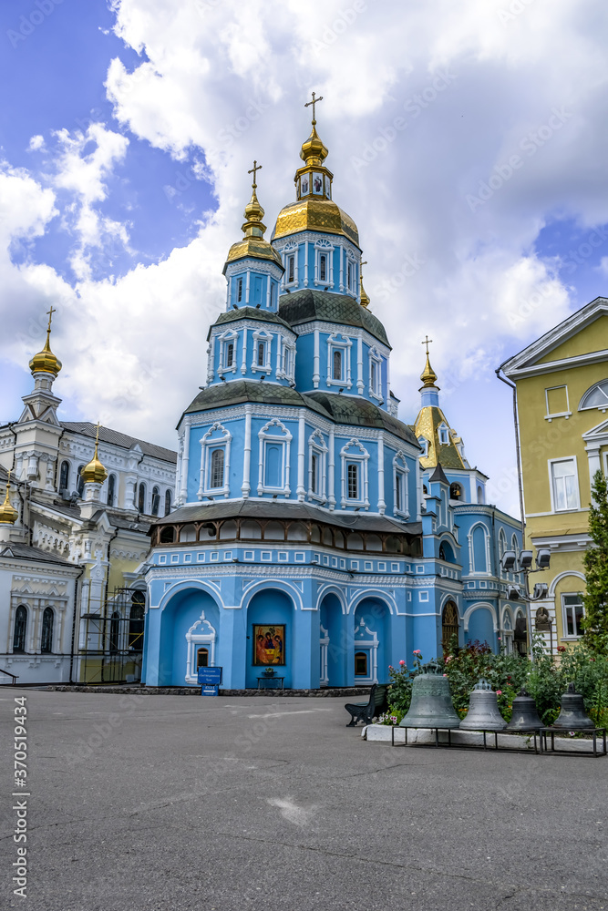 Kharkiv, Ukraine - July 20, 2020: Pokrovsky Cathedral in Kharkov with light blue facades and golden roofs, vertical. The oldest Orthodox church in the city. Background with copy space