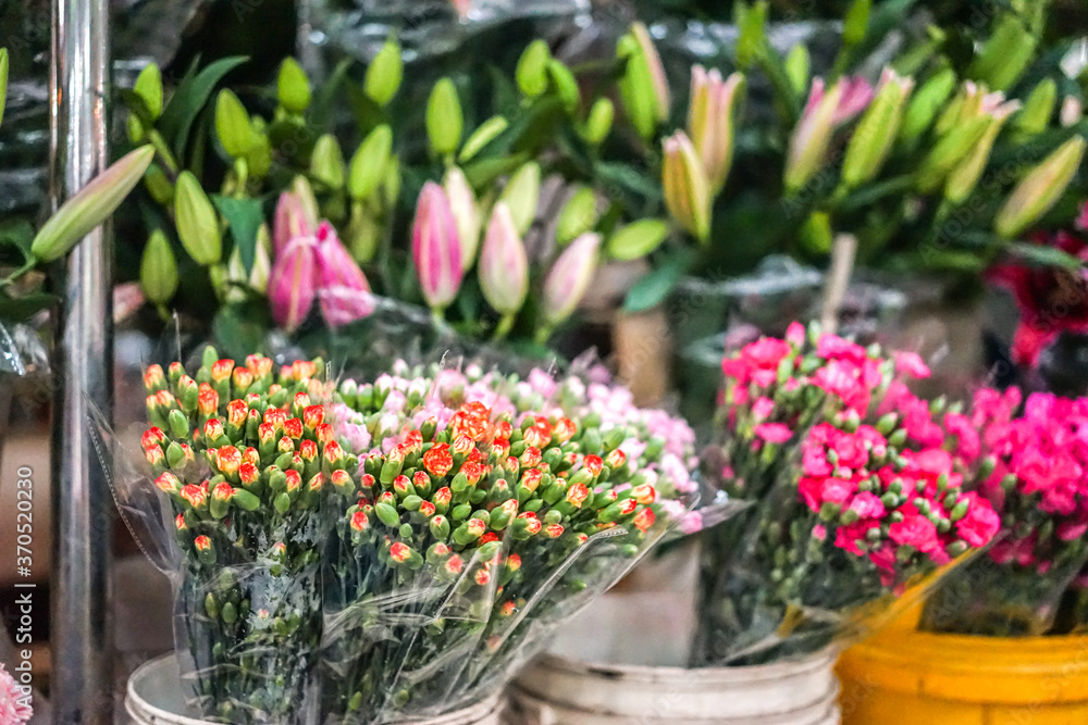 Carnations and lilies on the flower's market, flowers for sale, spring flora, decorative bouquet, soft focus, film grain