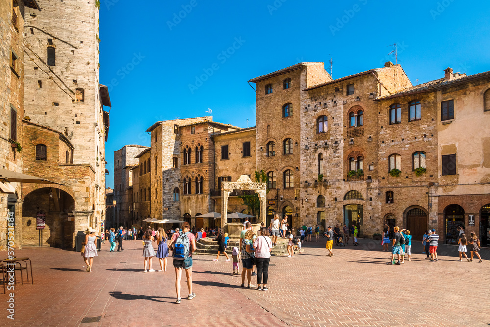Gorgeous view of the Piazza della Cisterna, main square of San Gimignano in Tuscany. Named after the underground cistern, capped by an octagonal pedestal built in 1346, it's a tourist attraction now.