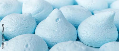 A lot of fresh sweet meringues of gentle blue color  banner background. Fluffy candies made with eggs and sugar close-up. Homemade delicacy  creamy treat  dessert  baking decor  pastry shop.