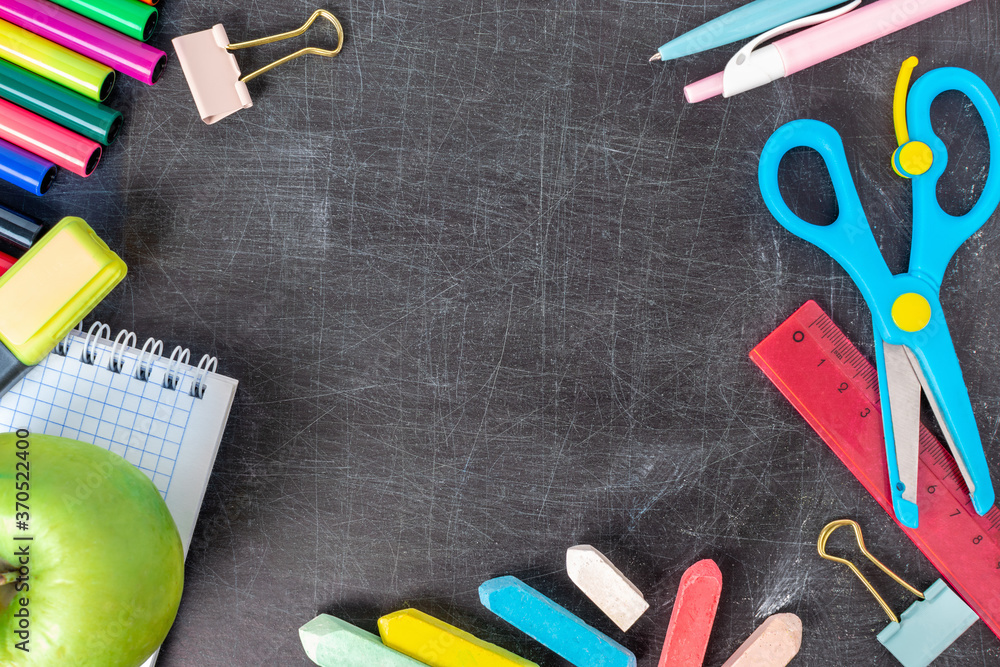 Back to school concept. Colorful crayons, pen, exercise book, scissors, markers and supplies on the old blackboard background with copy space.  Chalkboard with pieces of chalk and stationery. Stock Photo | Adobe Stock