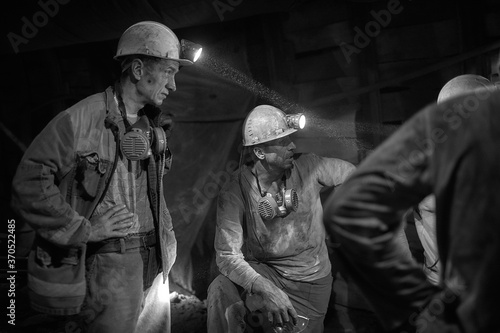 Silhouette of a working miner in a mine photo